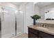 Bright bathroom featuring a vanity with granite countertops, framed mirror, and a walk-in shower with seamless glass doors at 17369 Blazing Star Cir, Clermont, FL 34714