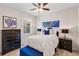 Comfortable bedroom boasts a ceiling fan, soft carpet, black furniture, a blue bench, and lots of natural light at 17369 Blazing Star Cir, Clermont, FL 34714