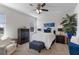 Relaxing bedroom with white walls, a soft carpet, ceiling fan, and stylish furniture with a white comforter and blue accents at 17369 Blazing Star Cir, Clermont, FL 34714