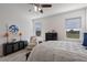 This cozy bedroom features carpet, ceiling fan, stylish decor, and lots of light from the two windows at 17369 Blazing Star Cir, Clermont, FL 34714