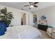 Comfortable bedroom with white bedding, plush carpet, ceiling fan, and decor with accents of blue and white at 17369 Blazing Star Cir, Clermont, FL 34714