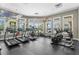 Well-equipped fitness center with treadmills, ellipticals, and stationary bikes and floor to ceiling windows at 17369 Blazing Star Cir, Clermont, FL 34714