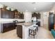 Modern kitchen with dark cabinetry, stainless steel appliances, granite countertops, and a central island with seating at 17369 Blazing Star Cir, Clermont, FL 34714