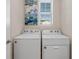 Bright laundry area with a side-by-side washer and dryer and decorative wall art at 17369 Blazing Star Cir, Clermont, FL 34714