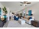 Spacious living room with neutral tones, a ceiling fan, tile flooring, and seamlessly flowing into the kitchen at 17369 Blazing Star Cir, Clermont, FL 34714