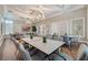 A bright meeting room featuring rectangular tables and gray upholstered chairs under modern chandeliers at 17369 Blazing Star Cir, Clermont, FL 34714