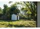 Spacious backyard with mature trees, green grass, shed, and wooden fence that enhances privacy at 2210 Grant Ave, Eustis, FL 32726