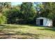 Large backyard featuring shed and mature trees offering shade and privacy at 2210 Grant Ave, Eustis, FL 32726