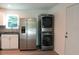 Modern kitchen featuring stainless steel refrigerator, stacked washer and dryer, and granite countertops at 2210 Grant Ave, Eustis, FL 32726