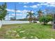 Grassy backyard enclosed with a white fence and mature palm trees at 2214 Lake Pointe Cir, Leesburg, FL 34748