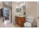 Well-lit bathroom featuring a wood vanity, commode, and tile flooring at 2214 Lake Pointe Cir, Leesburg, FL 34748