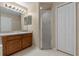 Bathroom with a neutral color palette, featuring a shower, a closet and a wooden vanity at 2214 Lake Pointe Cir, Leesburg, FL 34748