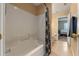 Bathroom with a white tiled shower and a peek to the adjacent bedroom at 2214 Lake Pointe Cir, Leesburg, FL 34748