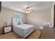 Cozy bedroom featuring a ceiling fan, neutral walls, carpeted floor, and window views at 2214 Lake Pointe Cir, Leesburg, FL 34748