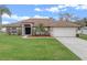 Charming single-story home with a well-manicured lawn and a two-car garage at 2214 Lake Pointe Cir, Leesburg, FL 34748