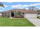 Charming single-story home with a well-manicured lawn and a two-car garage at 2214 Lake Pointe Cir, Leesburg, FL 34748