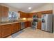 Kitchen featuring wooden cabinets, stainless appliances, and granite countertops at 2214 Lake Pointe Cir, Leesburg, FL 34748