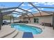 Sparkling pool with a screen enclosure, lounge chairs and lush landscaping at 2214 Lake Pointe Cir, Leesburg, FL 34748