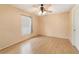 A standard bedroom with wood laminate flooring, ceiling fan, and a window for natural light at 2256 Lake Pointe Cir, Leesburg, FL 34748