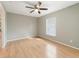 Bedroom with neutral walls, ceiling fan, and wood-look flooring offers a bright, relaxing space at 2256 Lake Pointe Cir, Leesburg, FL 34748