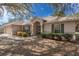 Charming home featuring a neutral color scheme, decorative shutters, and a well-maintained lawn with mature trees at 2256 Lake Pointe Cir, Leesburg, FL 34748