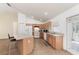 Bright kitchen featuring an island with seating, tile flooring, and a view of the backyard through the sliding glass door at 2256 Lake Pointe Cir, Leesburg, FL 34748