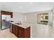 Bright kitchen with stainless steel refrigerator, center island, and sliding glass doors to the outside at 2365 Palm Park Loop, Clermont, FL 34714