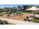 Community playground with green play structures and bench seating next to a sidewalk and landscaping at 2365 Palm Park Loop, Clermont, FL 34714