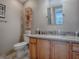 Bathroom showcasing a wood vanity with granite countertop, tile floor, and ample lighting at 2506 Greenhill Trl, The Villages, FL 32162