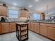 Spacious kitchen with wooden cabinets, a functional kitchen island, and granite countertops for ample workspace at 2506 Greenhill Trl, The Villages, FL 32162