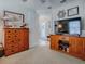 Living area featuring wooden cabinet and map, doorway, and flatscreen TV at 2506 Greenhill Trl, The Villages, FL 32162