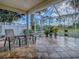 Enclosed patio with tiled floor, potted plants, and seating area to enjoy pleasant views of the surrounding yard at 2506 Greenhill Trl, The Villages, FL 32162