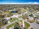 Panoramic aerial view of a vibrant retirement community with well-maintained homes and lush landscaping around a scenic pond at 25546 Belle Alliance, Leesburg, FL 34748