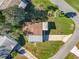 Aerial view of a cozy home with a tidy lawn, complemented by mature trees and a convenient driveway in a peaceful setting at 25546 Belle Alliance, Leesburg, FL 34748