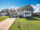 Charming single-story home featuring well-maintained landscaping and a covered carport on a sunny day at 25546 Belle Alliance, Leesburg, FL 34748