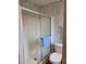 A standard shower with glass doors sits next to a toilet in a compact bathroom at 263 Pinewood Dr, Eustis, FL 32726