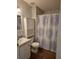 Cozy bathroom featuring a white vanity, toilet with storage, and shower with patterned curtain at 263 Pinewood Dr, Eustis, FL 32726