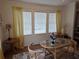 Sunlit dining area featuring a glass table and decoratively-curtained windows at 263 Pinewood Dr, Eustis, FL 32726