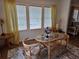 Sunlit dining area featuring a glass table and decoratively-curtained windows at 263 Pinewood Dr, Eustis, FL 32726