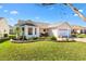 Charming one-story home featuring manicured lawn, lovely landscaping, and a two-car garage at 3176 Atwell Ave, The Villages, FL 32162