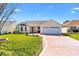 Charming one-story home featuring manicured lawn, lovely landscaping, and a two-car garage at 3176 Atwell Ave, The Villages, FL 32162