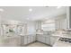 Bright kitchen with white cabinets, tile backsplash, and stainless steel appliances at 3176 Atwell Ave, The Villages, FL 32162