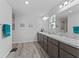 Bathroom featuring a double vanity with granite counters and wood-look tile floors at 3318 Dzuro Dr, Oxford, FL 34484