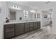 Bathroom featuring a double vanity with granite counters and wood-look tile floors at 3318 Dzuro Dr, Oxford, FL 34484