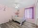 Bedroom with a ceiling fan, closet, and a window with pink curtains at 3318 Dzuro Dr, Oxford, FL 34484