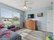 Bedroom featuring a ceiling fan, a large window with blinds, and a wooden dresser at 3318 Dzuro Dr, Oxford, FL 34484