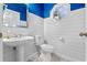 Charming half bathroom with striking blue accents, shiplap walls and a pedestal sink at 4324 Leafway Cir, Leesburg, FL 34748