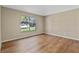 Bright bedroom showcases laminate floors and a large window with a green outdoor view at 4324 Leafway Cir, Leesburg, FL 34748