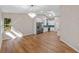 Open dining area with a chandelier and wood-look floors, connecting the living room and kitchen at 4324 Leafway Cir, Leesburg, FL 34748