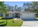 Charming single story home with a well manicured lawn and an attached two car garage at 4324 Leafway Cir, Leesburg, FL 34748